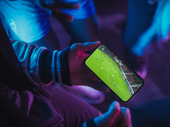 person using phone to watch football